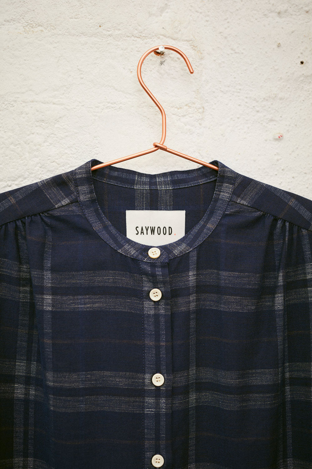 Detail of Rosa shirtdress neckline and gathered puff sleeves in navy check surplus cotton by Saywood
