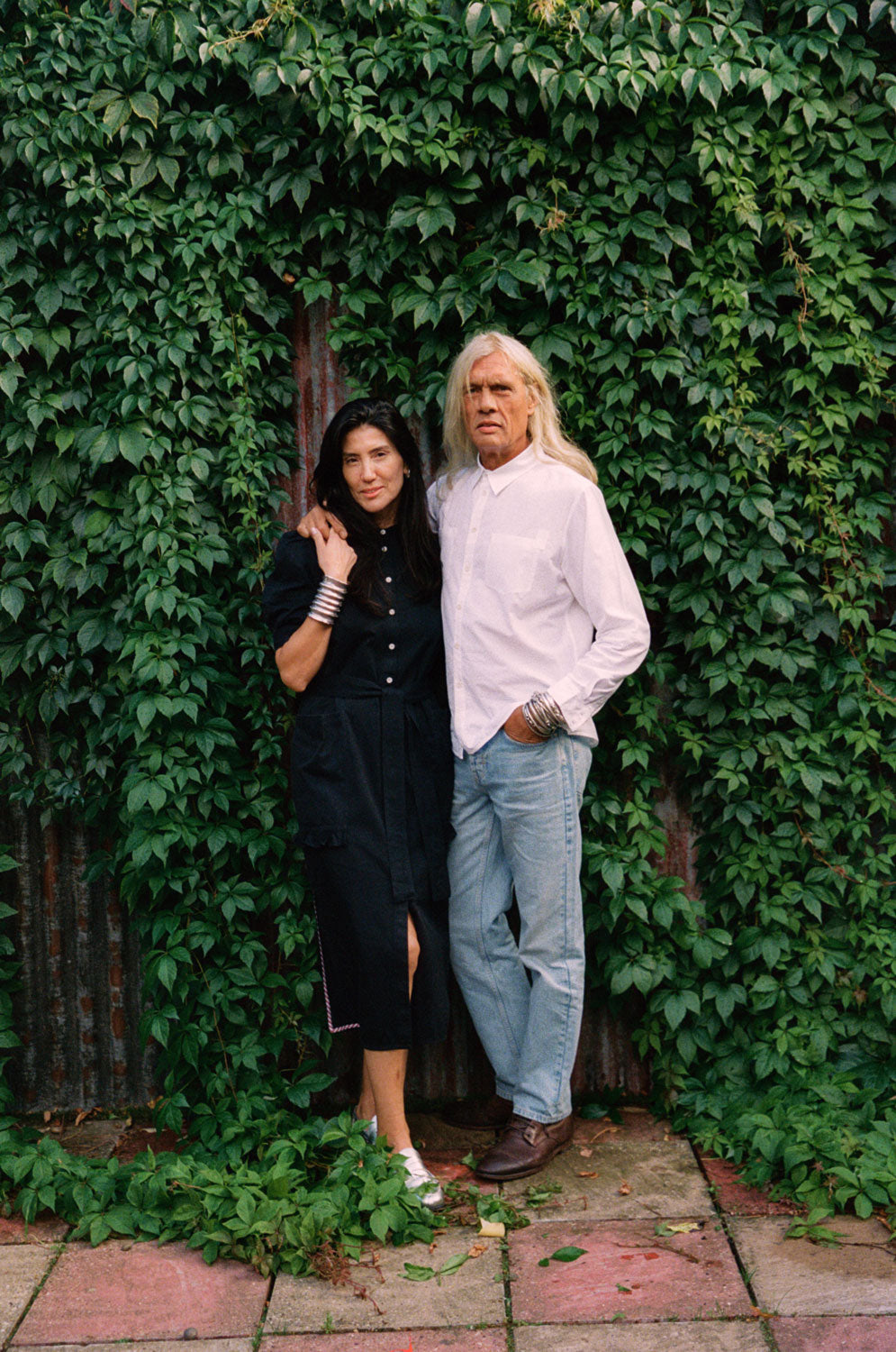 Couple styling: woman in Rosa black Japanese denim dress and man in white patch pocket shirt, made in London by Saywood
