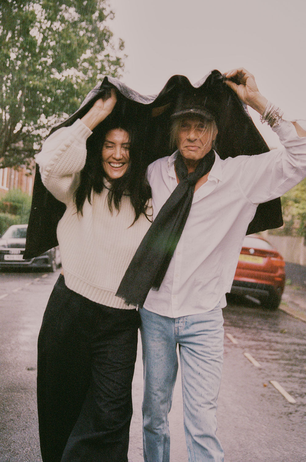 Adams cream sweater styled with black Amelia wide leg trousers and white shirt, couple outdoor lifestyle shot by Saywood