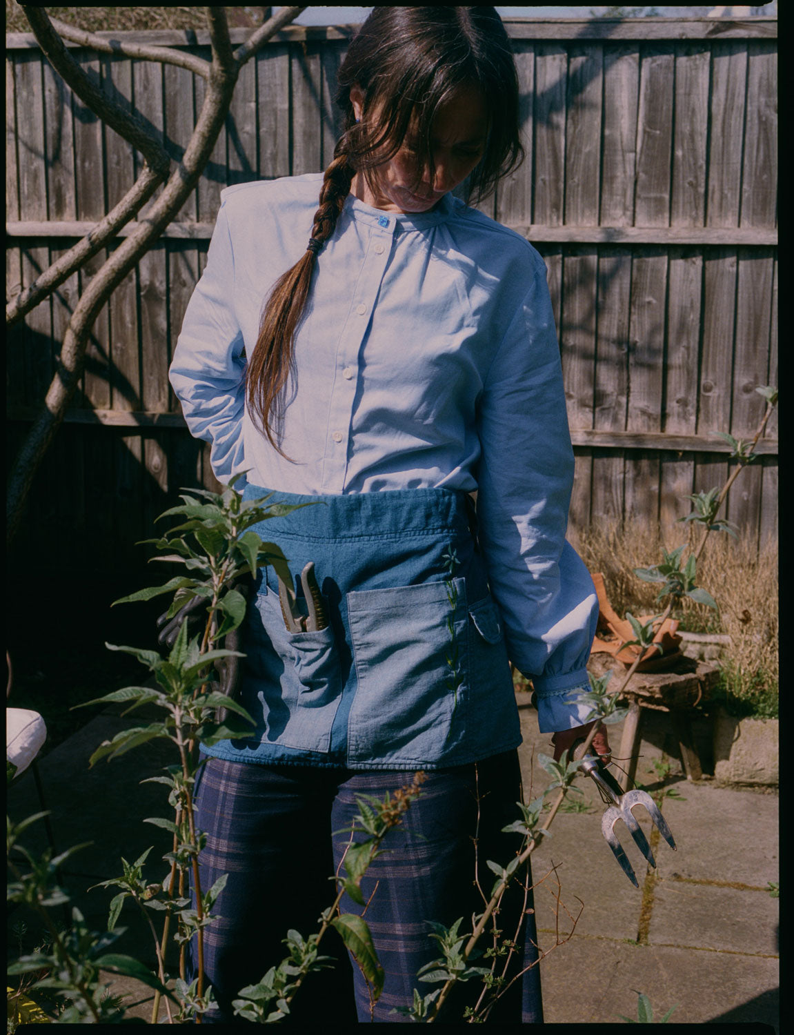 Marie pale blue A-line blouse with vintage glass button worn with Amelia navy check trousers and Gardener's Tool Belt by Saywood