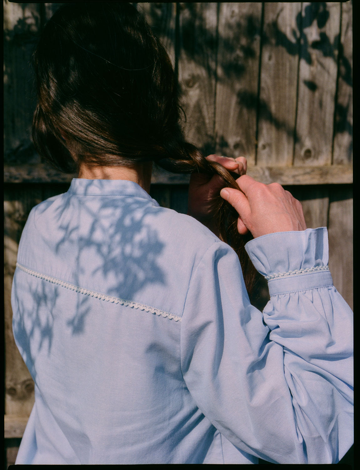 Back view of Marie A-line blouse in pale blue recycled cotton showing lace trim and gathered frill cuffs by Saywood